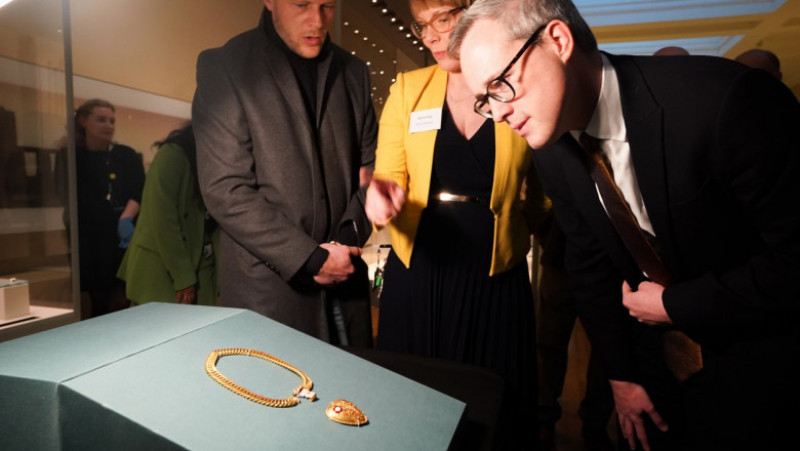 Charlie Clarke (stânga) asistă la expunerea pandantivului pe care l-a găsit la British Museum. Foto: Profimedia Images