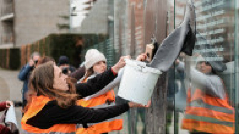 Protestatare aruncând cu vopsea pe un geam. Foto: Profimedia Images | Poza 21 din 22