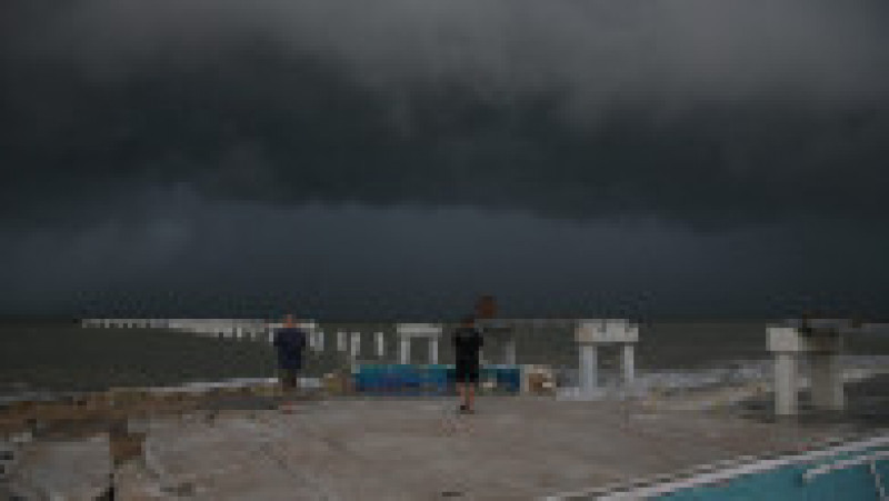 Oamenii se uită pe plajă la valuri în timp ce uraganul Idalia se apropie de Florida. Foto: Profimedia Images | Poza 6 din 6