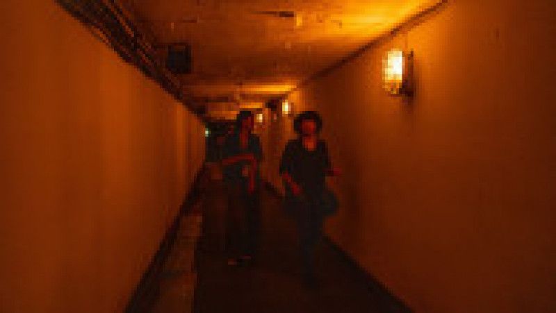 Ca să viziteze fosta termocentrală ascunsă într-un munte, turiștii trebuie să treacă printr-un tunel îngust echipat cu lanterne industriale care emană o lumină caldă. Foto: Profimedia Images | Poza 5 din 13