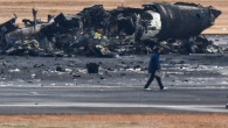 Imagini de pe aeroportul din Tokyo, cu epava înnegrită a avionului distrus ieri de flăcări. FOTO: Profimedia Images | Poza 1 din 10