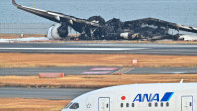 Imagini de pe aeroportul din Tokyo, cu epava înnegrită a avionului distrus ieri de flăcări. FOTO: Profimedia Images | Poza 3 din 10