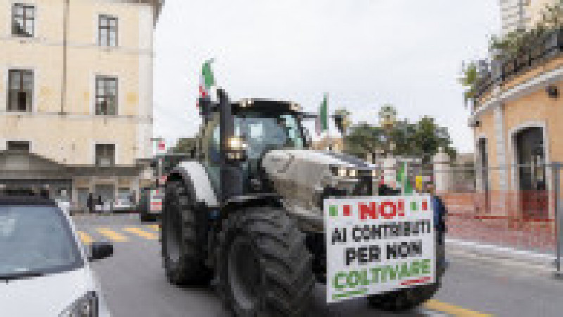 Aceste vehicule, din care care câte unul a fost vopsit în verde, alb şi roşu, culorile drapelului Italiei, fac parte dintr-o adunare cu peste 300 de tractoare ale agricultorilor care s-au strâns de mai multe zile la porţile Romei, unde aşteaptă autorizaţia să intre în centrul oraşului. Foto Profimedia Images | Poza 12 din 18