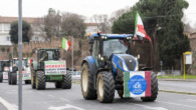 Aceste vehicule, din care care câte unul a fost vopsit în verde, alb şi roşu, culorile drapelului Italiei, fac parte dintr-o adunare cu peste 300 de tractoare ale agricultorilor care s-au strâns de mai multe zile la porţile Romei, unde aşteaptă autorizaţia să intre în centrul oraşului. Foto Profimedia Images | Poza 16 din 18