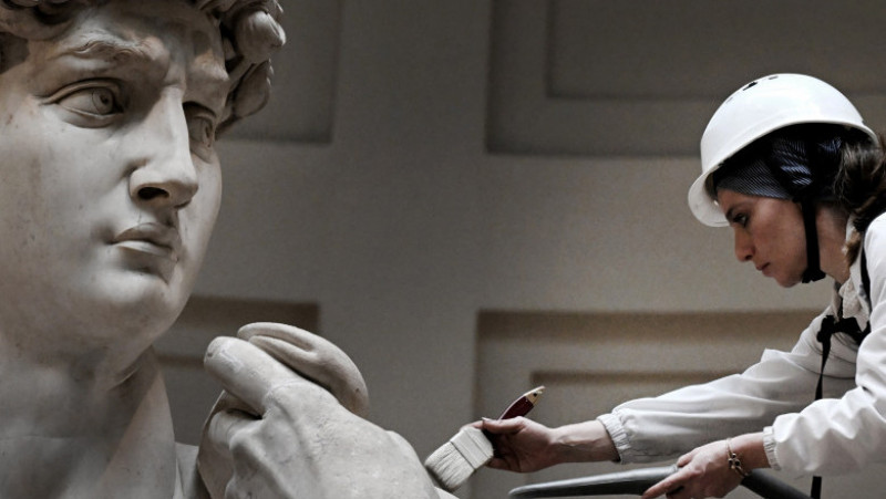 Restauratoarea italiană, Eleonora Pucci, curăță de praf statuia David a lui Michelangelo, la Galleria dell'Accademia din Florenţa. Foto: Profimedia Images