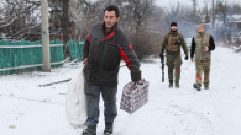 Un bărbat cară niște sacoșe pe o stradă în Avdiivka. Foto: Profimedia Images | Poza 3 din 13