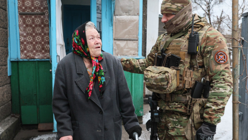 O femeie în vârstă vorbește cu un soldat rus în Avdiivka. Foto: Profimedia Images