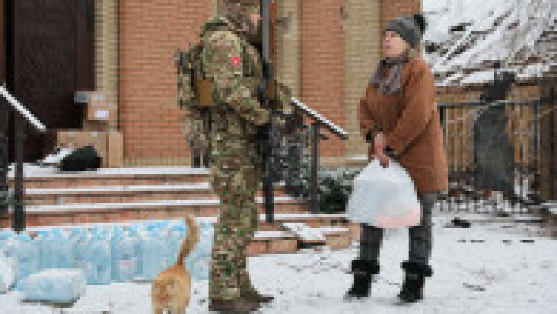 Un soldat rus, o localnică și o pisică pe o stradă în Avdiivka. Foto: Profimedia Images | Poza 13 din 13