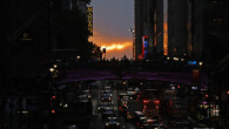 Mii de new-yorkezi s-au oprit cu telefoanele și camerele în mâini, pe trotuare, poduri și chiar în mijlocul drumului, ca să fotografieze cel mai frumos apus de soare, supranumit „Manhattanhenge”. FOTO Profimedia Images | Poza 9 din 15