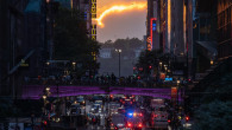 Mii de new-yorkezi s-au oprit cu telefoanele și camerele în mâini, pe trotuare, poduri și chiar în mijlocul drumului, ca să fotografieze cel mai frumos apus de soare, supranumit „Manhattanhenge”. FOTO Profimedia Images | Poza 6 din 15