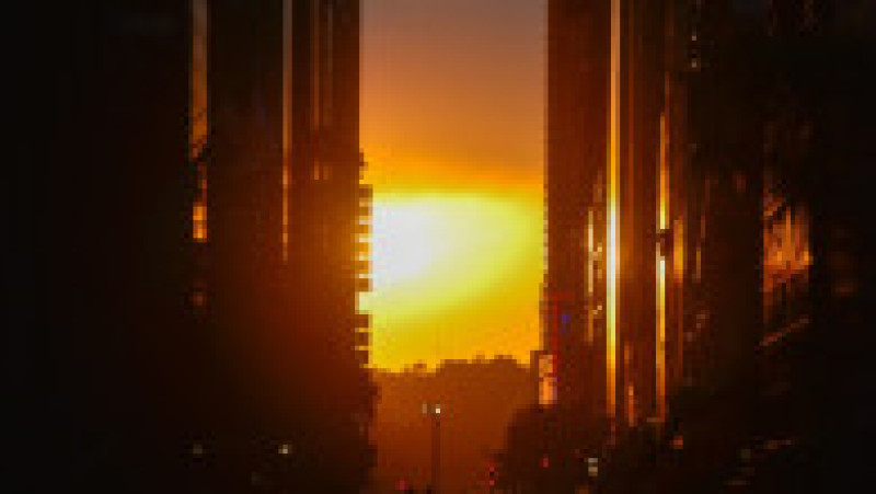 Mii de new-yorkezi s-au oprit cu telefoanele și camerele în mâini, pe trotuare, poduri și chiar în mijlocul drumului, ca să fotografieze cel mai frumos apus de soare, supranumit „Manhattanhenge”. FOTO Profimedia Images | Poza 8 din 15