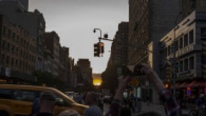 Mii de new-yorkezi s-au oprit cu telefoanele și camerele în mâini, pe trotuare, poduri și chiar în mijlocul drumului, ca să fotografieze cel mai frumos apus de soare, supranumit „Manhattanhenge”. FOTO Profimedia Images | Poza 10 din 15