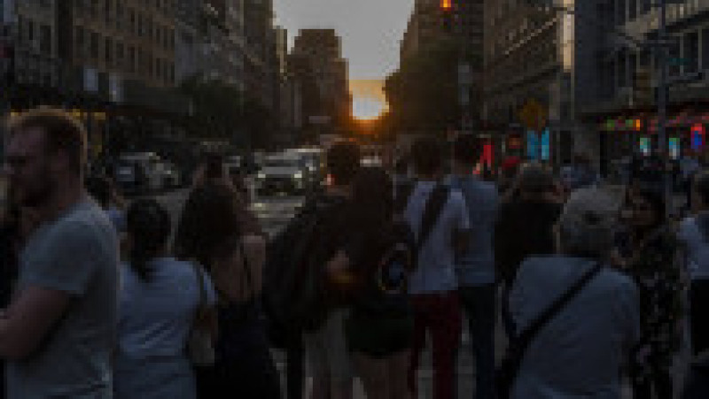 Mii de new-yorkezi s-au oprit cu telefoanele și camerele în mâini, pe trotuare, poduri și chiar în mijlocul drumului, ca să fotografieze cel mai frumos apus de soare, supranumit „Manhattanhenge”. FOTO Profimedia Images | Poza 11 din 15