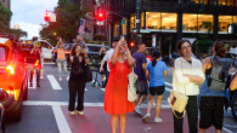 Mii de new-yorkezi s-au oprit cu telefoanele și camerele în mâini, pe trotuare, poduri și chiar în mijlocul drumului, ca să fotografieze cel mai frumos apus de soare, supranumit „Manhattanhenge”. FOTO Profimedia Images | Poza 12 din 15