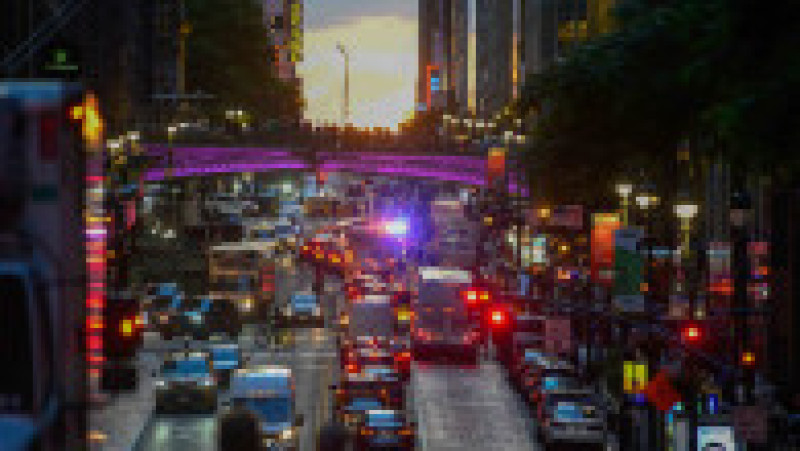 Mii de new-yorkezi s-au oprit cu telefoanele și camerele în mâini, pe trotuare, poduri și chiar în mijlocul drumului, ca să fotografieze cel mai frumos apus de soare, supranumit „Manhattanhenge”. FOTO Profimedia Images | Poza 13 din 15