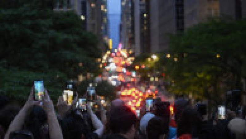 Mii de new-yorkezi s-au oprit cu telefoanele și camerele în mâini, pe trotuare, poduri și chiar în mijlocul drumului, ca să fotografieze cel mai frumos apus de soare, supranumit „Manhattanhenge”. FOTO Profimedia Images | Poza 14 din 15