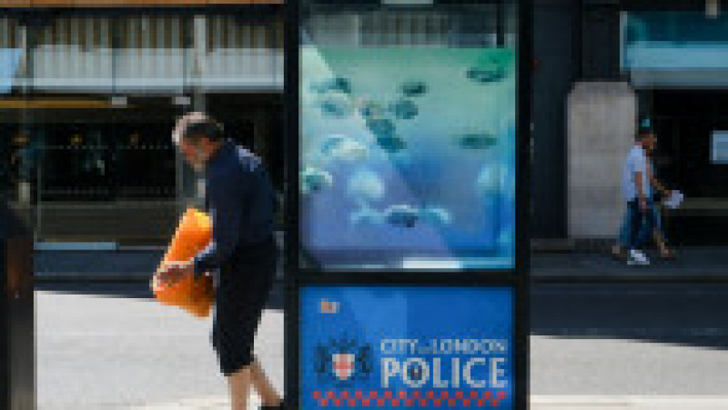 Oamenii s-au îngrămădit să își facă poze cu peștii piranha care înoată pe geamul unei cabine stradale folosită de poliția din Londra. Foto: Profimedia Images | Poza 7 din 15