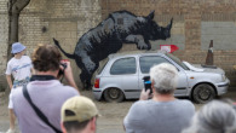 Trecători fac poze la o lucrare artistică realizată de Banksy în Londra. Foto: Profimedia Images | Poza 2 din 5