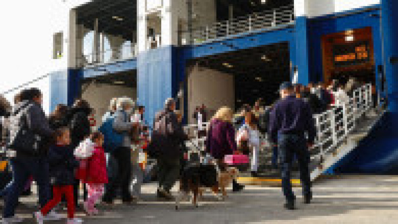 Sute de oameni se îmbarcă pe un feribot pentru a părăsi insula Santorini. Foto: Profimedia | Poza 8 din 9