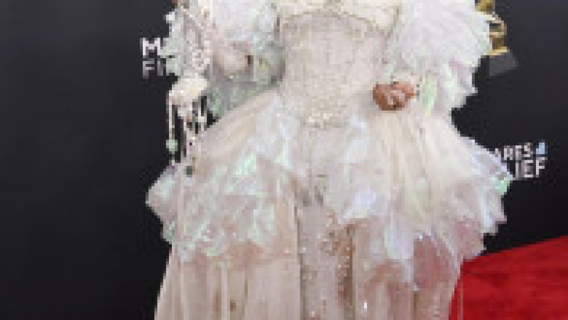 Câștigătoarea unui Grammy, Sierra Ferrell, a defilat pe covorul roșu într-o rochie de bal acoperită cu perle, care era mai mult costum decât couture. Look-ul includea o fustă din tul perlat care o copleșea, iar sceptrul și coronita asortate erau un pic prea exagerate. Foto: Profimedia | Poza 7 din 9