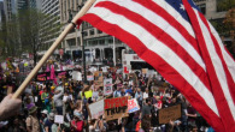 Steagul Statelor Unite flutură deasupra unei mulțimi de manifestanți adunați în centrul New York-ului. Oamenii au venit cu mesaje precum „Libertate, nu tiranie”. Foto. Profimedia | Poza 6 din 9
