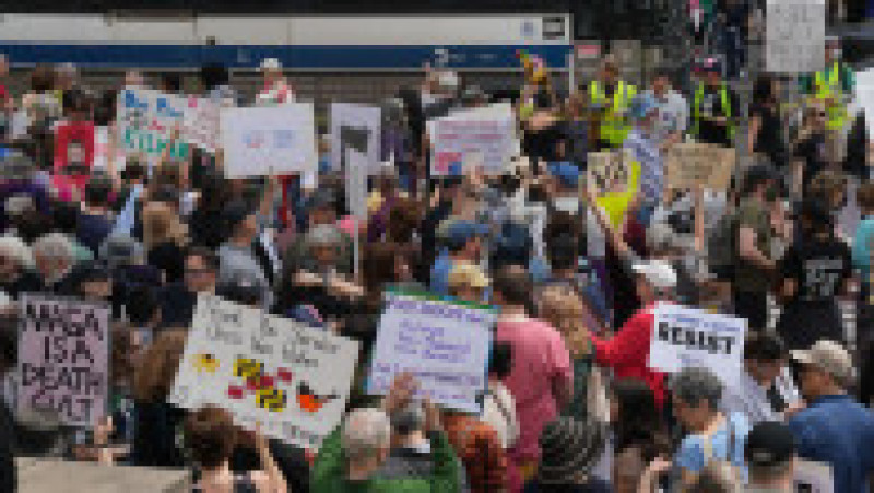 April 19, 2025, New York, New York, USA: People protest on Earth Day at the Our City, Our Fight: Protect Migrants, Protect the Planet on April 19, 2025 in New York. (Credit Image: ? Bryan Smith/ZUMA Press Wire)
O mulțime de protestatari în fața unei stații de autobuz din New York afișează pancarte variate: de la mesaje anti-MAGA, până la apeluri pentru protecția migranților și reglementarea armelor. Foto: Profimedia | Poza 8 din 9