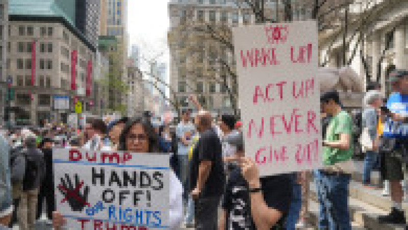 O participantă la protestul anti-Trump din New York poartă o pancartă cu mesajul „Jos mâinile de pe drepturile noastre, Trump”. Foto: Profimedia | Poza 5 din 9