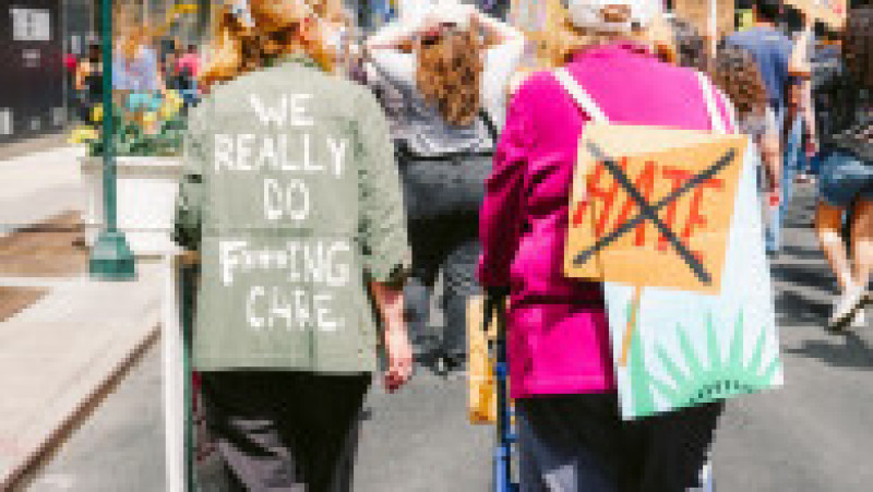 Două femei participă la protestele din centrul New York-ului. Una dintre ele poartă mesajul „Ne pasă cu adevărat”, în timp ce cealaltă afişează o pancartă cu mesaj anti-ură. Foto: Profimedia | Poza 2 din 9