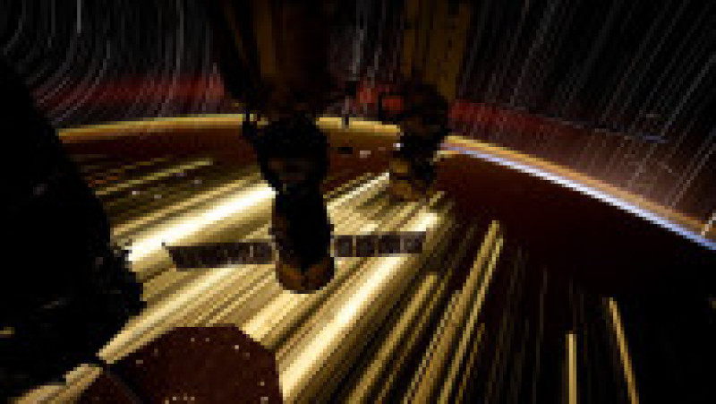 Lumina galbenă (la 120 de kilometri altitudine) și cea roșiatică (la 400 de kilometri) din apropiere de orizont sunt emise de atmosfera Pământului. Liniile aurii sunt luminile reflectate de sateliții Starlink. Foto: Profimedia Images | Poza 3 din 16