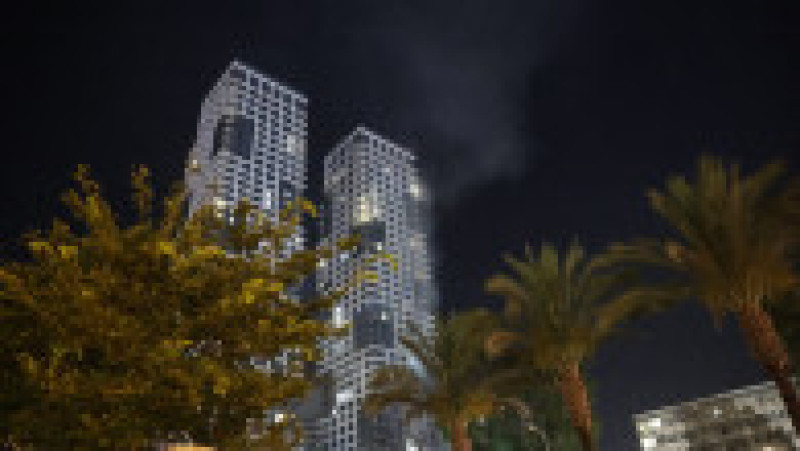 Foc și fum se ridică dintr-o clădire, care ar fi fost lovită de o rachetă lansată din Iran, în centrul orașului Tel Aviv, pe 13 iunie 2025. Foto: Profimedia | Poza 17 din 19
