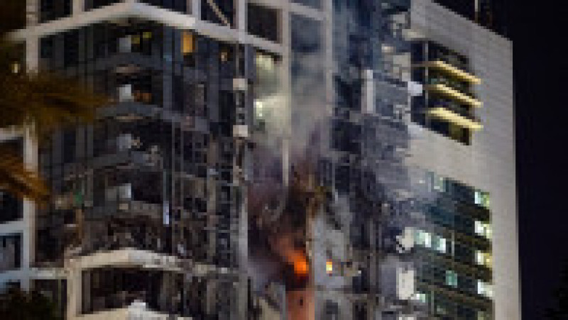 Foc și fum se ridică dintr-o clădire, care ar fi fost lovită de o rachetă lansată din Iran, în centrul orașului Tel Aviv, pe 13 iunie 2025. Foto: Profimedia | Poza 16 din 19