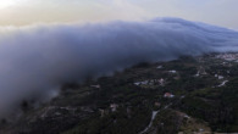 Fotografie realizată pe 29 iunie 2025 cu o dronă, care arată un rar „nor rulou”, un nor uriaș orizontal care avansează de la orizont spre plajele Oceanului Atlantic în timpul valului de căldură din apropierea Cabo da Roca, sud-vestul Portugaliei. Foto: Profimedia | Poza 4 din 4