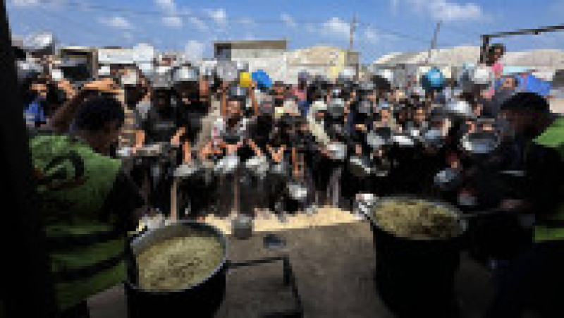 Palestinienii așteaptă să primească alimente de la o cantină caritabilă, în contextul unei crize alimentare, în Khan Yunis, Fâșia Gaza. Sursa: Profimedia | Poza 2 din 12