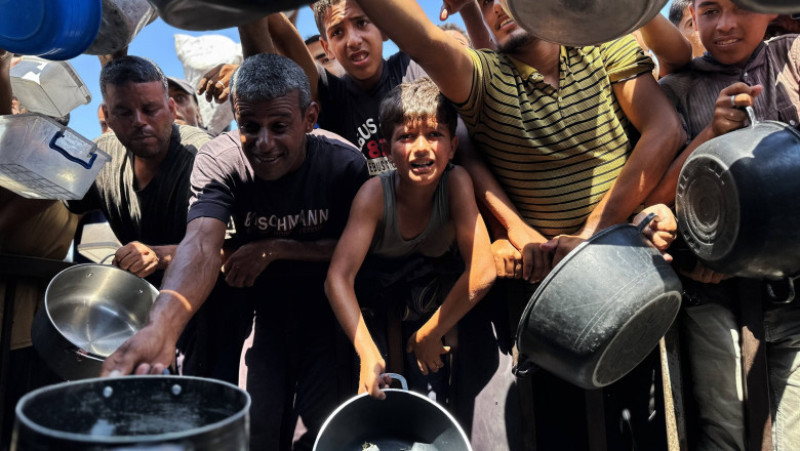 Palestinienii așteaptă să primească alimente de la o cantină caritabilă, în contextul unei crize alimentare, în Khan Yunis, Fâșia Gaza. Sursa: Profimedia