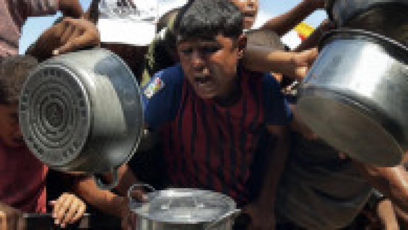 Palestinienii așteaptă să primească alimente de la o cantină caritabilă, în contextul unei crize alimentare, în Khan Yunis, Fâșia Gaza. Sursa: Profimedia | Poza 4 din 12