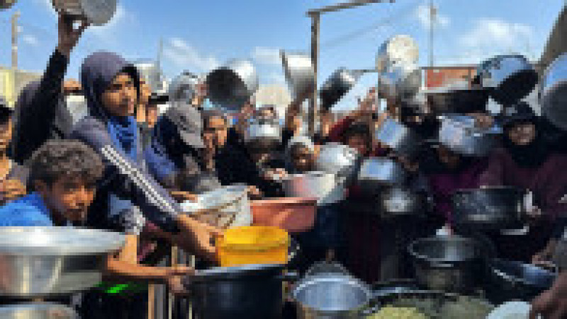 Palestinienii așteaptă să primească alimente de la o cantină caritabilă, în contextul unei crize alimentare, în Khan Yunis, Fâșia Gaza. Sursa: Profimedia | Poza 3 din 12