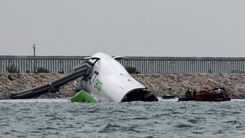Un avion de marfă zace parțial în mare după ce a ieșit de pe pistă în timpul aterizării la Aeroportul Internațional Hong Kong din Hong Kong, China, 20 octombrie 2025. Foto: REUTERS / Tyrone Siu
