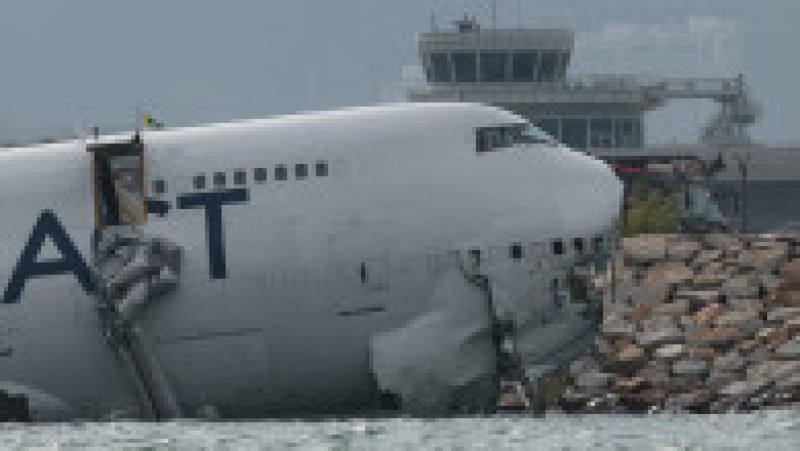 Un avion de marfă zace parțial în mare după ce a ieșit de pe pistă în timpul aterizării la Aeroportul Internațional Hong Kong din Hong Kong, China, 20 octombrie 2025. Foto: REUTERS / Tyrone Siu | Poza 12 din 13