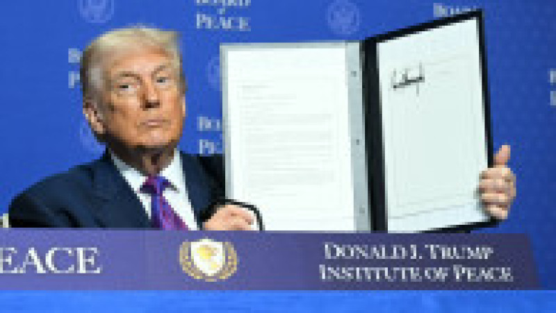 Donald Trump prezintă un document de rezoluție pe care l-a semnat în cadrul reuniunii inaugurale a „Consiliului pentru Pace”, pe 19 februarie 2026. Foto: Profimedia | Poza 8 din 8