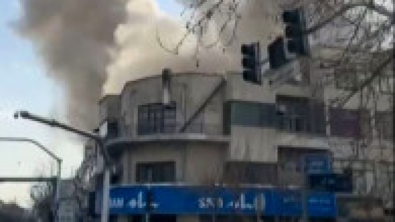 Această captură video preluată din imagini UGC postate pe rețelele sociale pe 28 februarie 2026 și verificată de echipele AFPTV din Paris arată o persoană mergând în timp ce un nor de fum se ridică în urma unei explozii raportate în Teheran. Foto: Profimedia | Poza 8 din 13