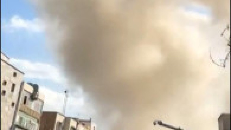 Această captură video preluată din imagini UGC postate pe rețelele sociale pe 28 februarie 2026 și verificată de echipele AFPTV din Paris arată o persoană mergând în timp ce un nor de fum se ridică în urma unei explozii raportate în Teheran. Foto: Profimedia | Poza 9 din 13