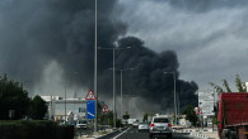 Șoferii trec pe lângă un nor de fum care se ridică în urma unui atac iranian raportat în districtul industrial din Doha, pe 1 martie 2026. Foto: Profimedia | Poza 5 din 11