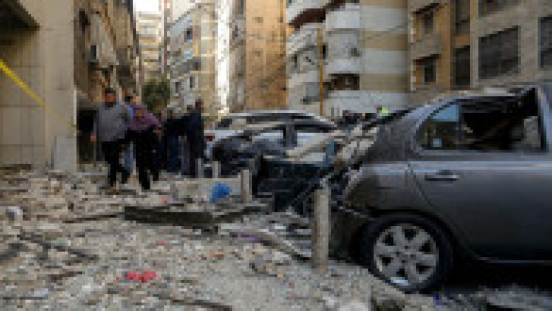 Un cuplu merge printre resturi și moloz în urma unui atac cu rachete israeliene care a vizat un apartament din centrul Beirutului. Foto: Profimedia | Poza 2 din 5