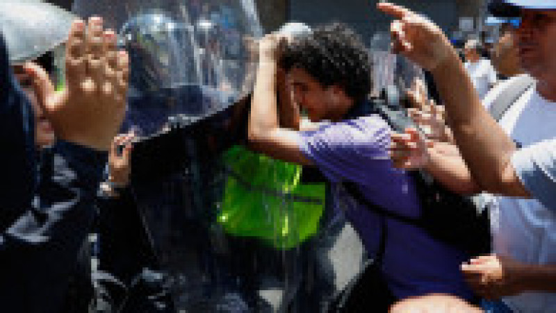 Oponenţi ai preşedintei interimare Delcy Rodriguez protestează la Caracas, pe 9 aprilie 2026, cerând majorarea salariilor şi pensiilor, cu un uriaş drapel venezuelean. Foto: Profimedia Images | Poza 6 din 8