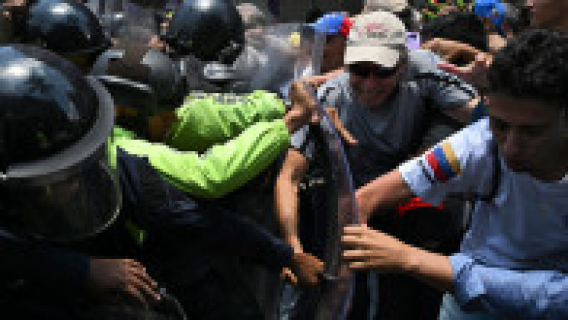 Oponenţi ai preşedintei interimare Delcy Rodriguez protestează la Caracas, pe 9 aprilie 2026, cerând majorarea salariilor şi pensiilor, cu un uriaş drapel venezuelean. Foto: Profimedia Images | Poza 7 din 8