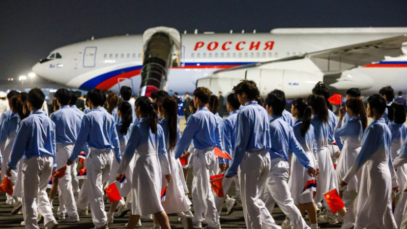 Primire cu fast pentru Putin la Beijing, la scurt timp după vizita lui Trump. „Încredere crescândă a Chinei în locul și poziția sa” 2 Tineri purtând steagurile Chinei și Rusiei îl întâmpină pe Vladimir Putin la sosirea la Beijing. Foto: Profimedia