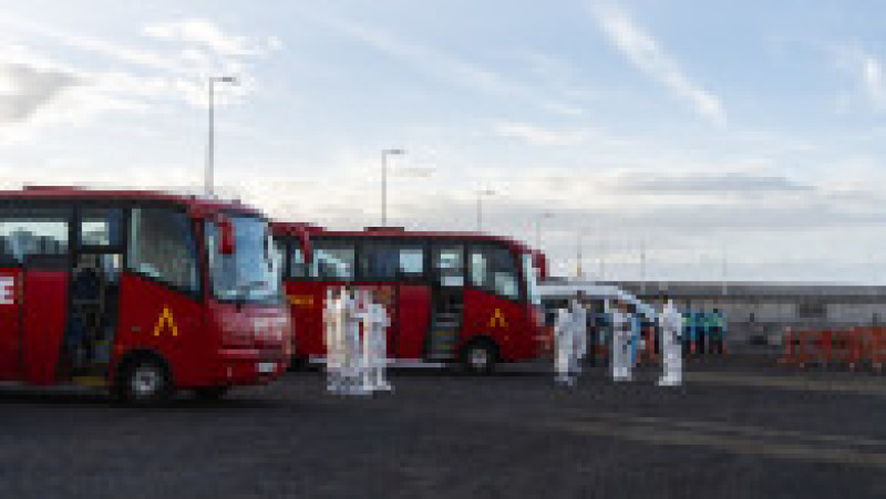 Autobuze ale UME și trupe ale Gărzii Civile așteaptă în port în timp ce nava de croazieră MV Hondius ancorează în apropierea portului Granadilla, pe 10 mai 2026, în Granadilla de Abona, Tenerife, Insulele Canare (Spania). | Poza 5 din 10