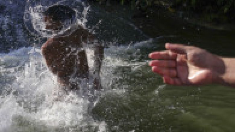 Lucrători din Sri Lanka, Nepal sau Pakistan s-au răcorit, alături de localnici din Clinceni sau Bragadiru, în apele râului Ciorogârla. Foto: Inquam Photos / Octav Ganea | Poza 7 din 7