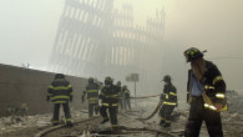 Pompierii lucrează sub montanții distruși, stâlpii verticali care odinioară se înălțau alături de pereții exteriori ai turnurilor World Trade Center, în urma atacului terorist asupra turnurilor gemene din sudul Manhattanului, marți, 11 septembrie 2001. Foto: MARK LENNIHAN / AP / Profimedia | Poza 5 din 5