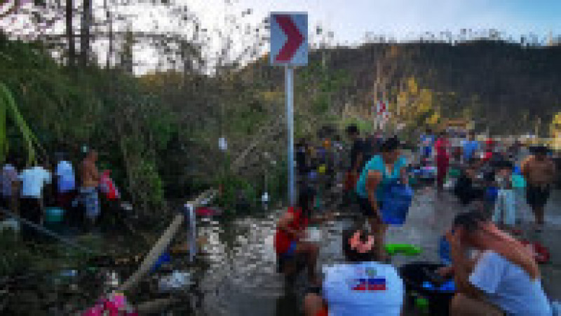 Oameni rămași fără locuință în urma taifunului își spală hainele într-un râu. Foto: Profimedia | Poza 3 din 8